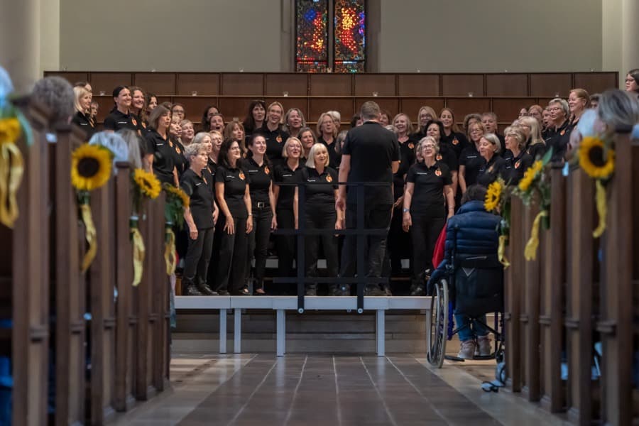 Chor beim Auftritt in der Kirche, von Sonnenblumen gesäumter Mittelgang